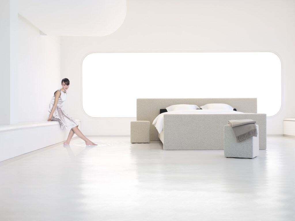 Frau im modernem weißem Zimmer mit Wasserbett